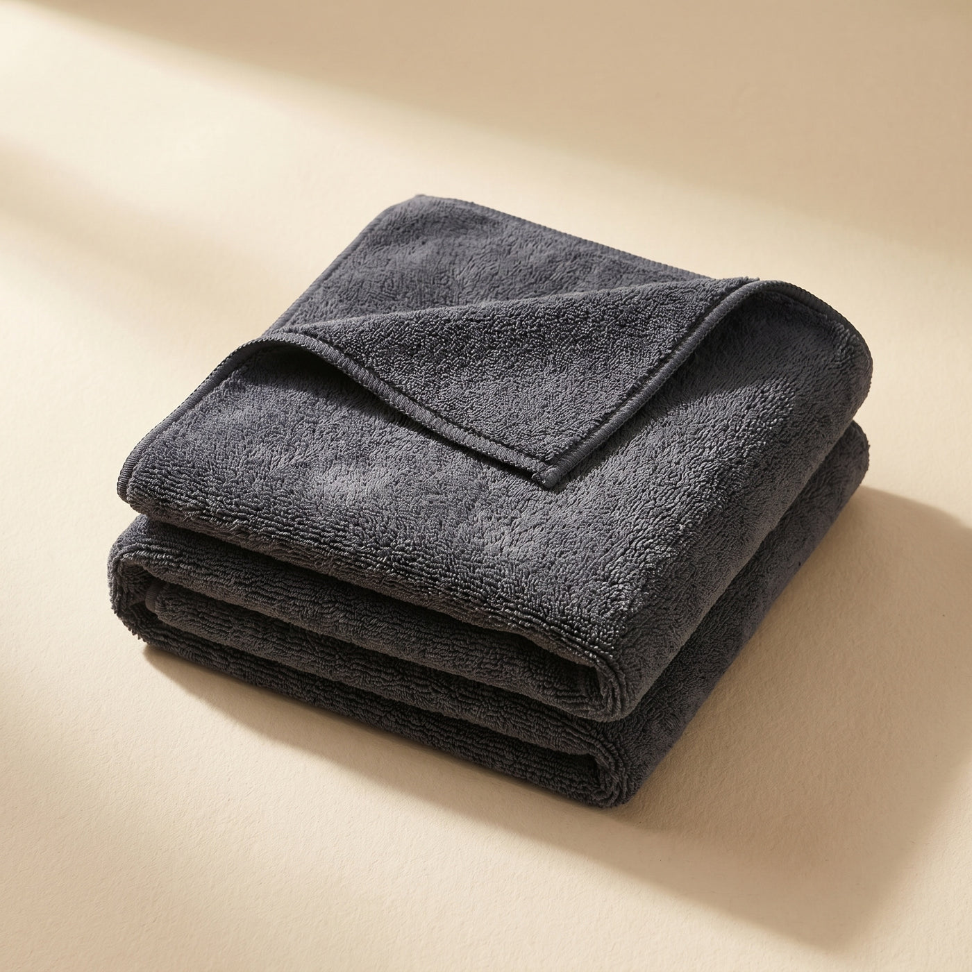 DRIVORA XL Microfiber Drying Towel — single dark charcoal grey folded towel on cream beige